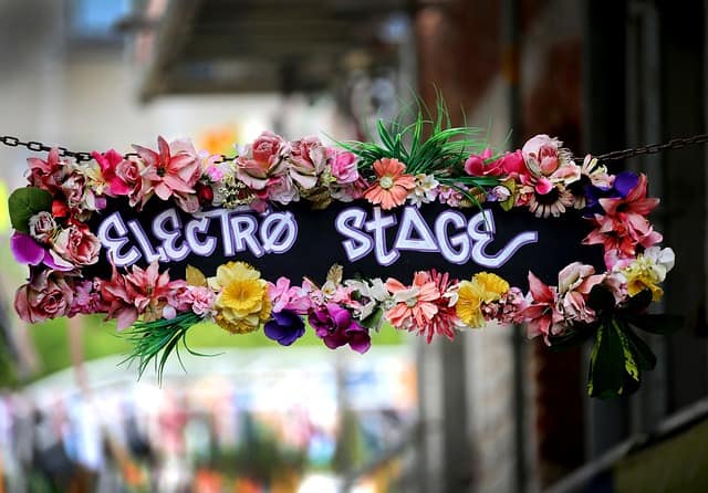 A flowered hanging sign with the text Electro Stage