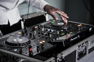 A DJ is performing on his Pioneer DJ gear